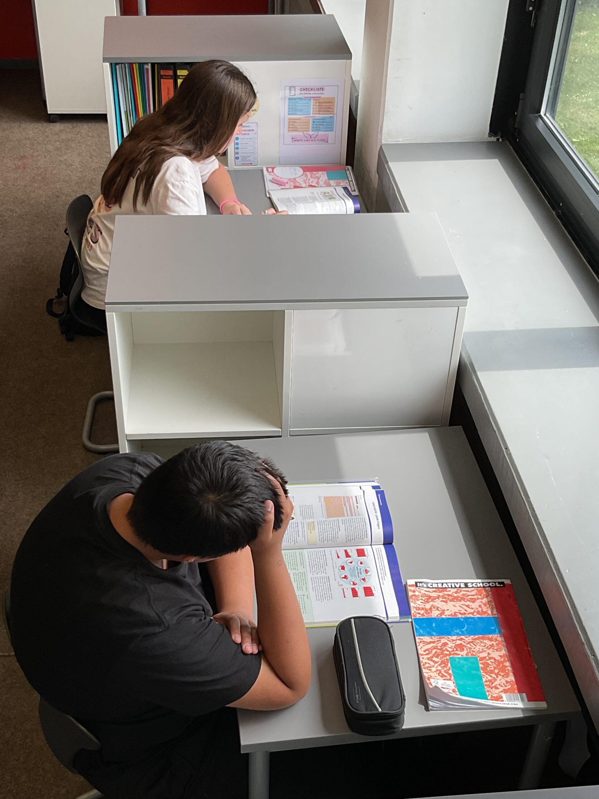 Kinder lernen an Schreibtischen im Klassenzimmer.
