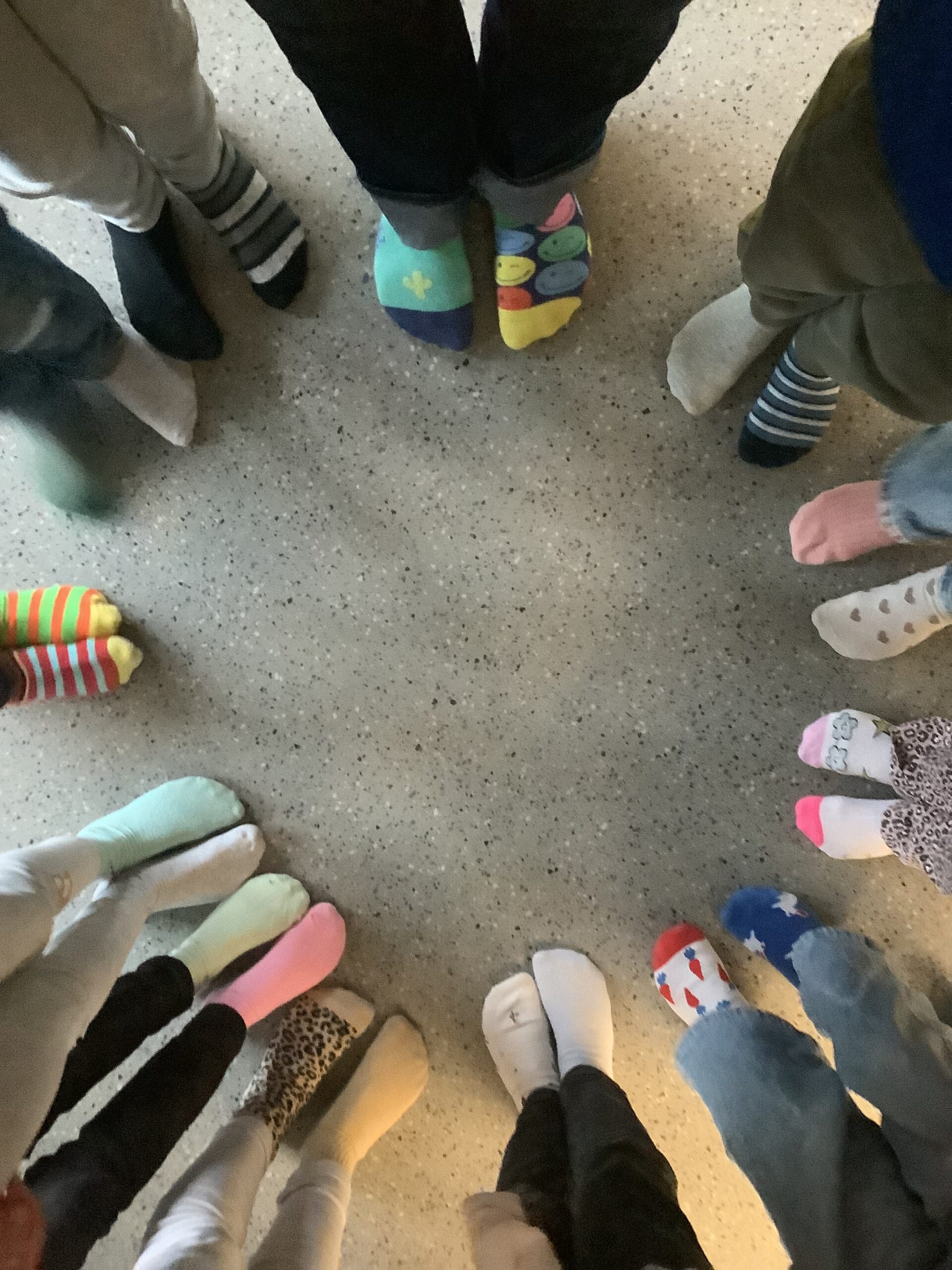 Schüler stehen im Kreis, man sieht nur die bunten Socken.